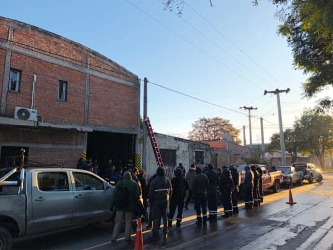 Operativo de emergencia con escalera y dotación en la vía pública al atardecer