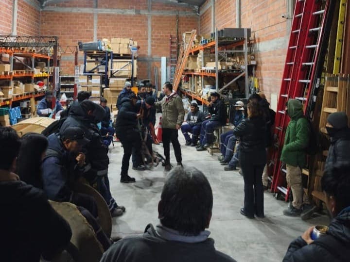 Equipo técnico reunido en un depósito con escaleras y andamios